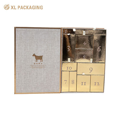 Groothandel boekvormige aftelling kalender cadeaubon, magnetische flipbox met 12 gouden laden, lint trek tab voor huidverzorgingscosmetica
