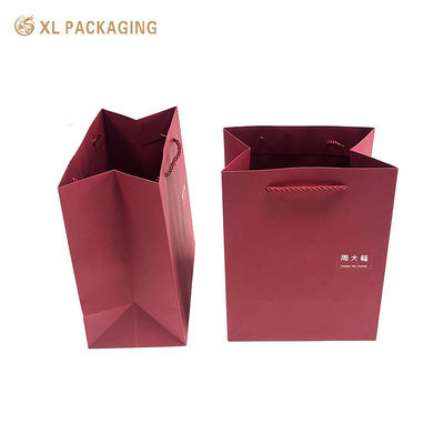 Luxe wijnrode papieren cadeautas met aangepast logo, versterkte gevouwen bodem en gedraaide papieren handgrepen voor premium winkelen en cadeauverpakkingen